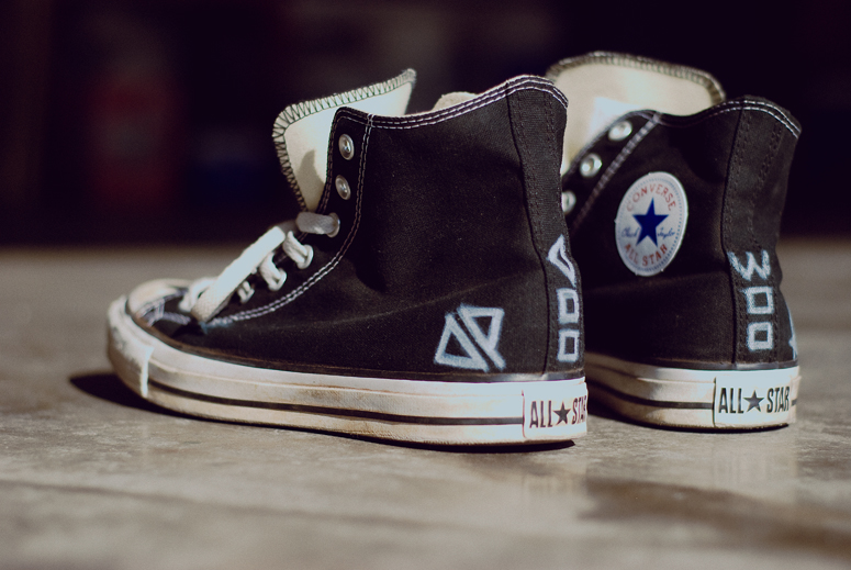 a pair of converse sneakers with blue and white lettering