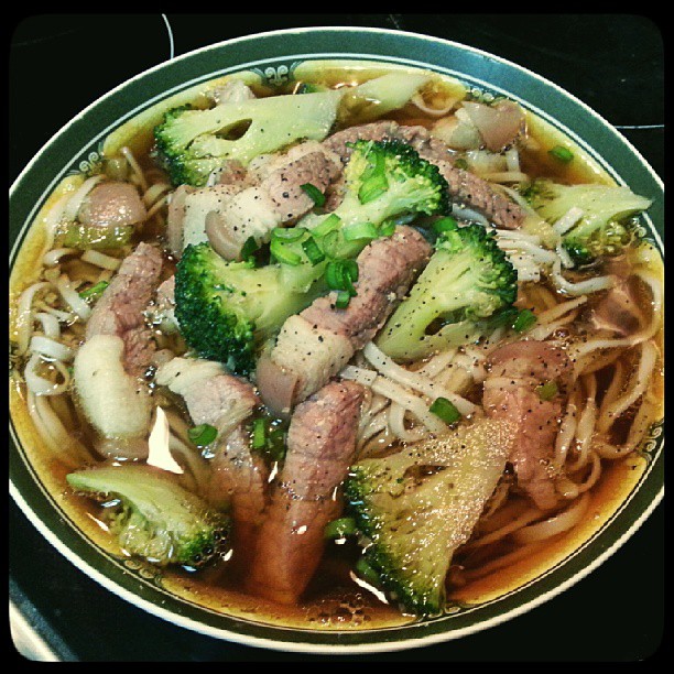 a bowl of pho bah with noodles and meat in broth