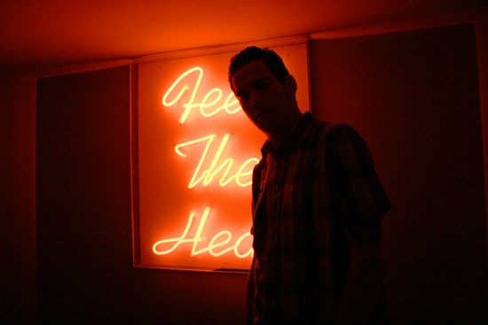 a man standing next to a neon sign in a room