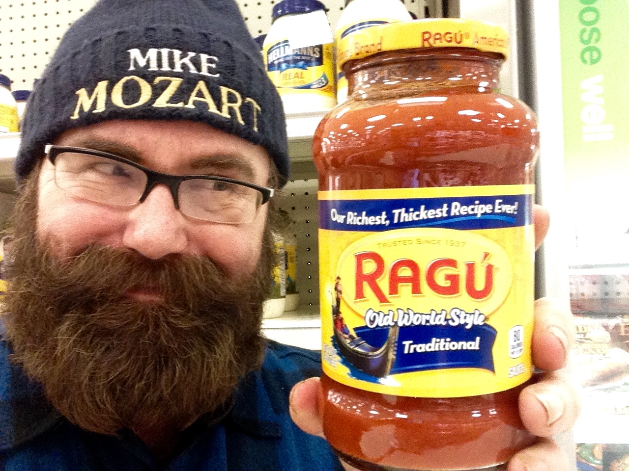 the bearded man holding the jar of tasty looking food