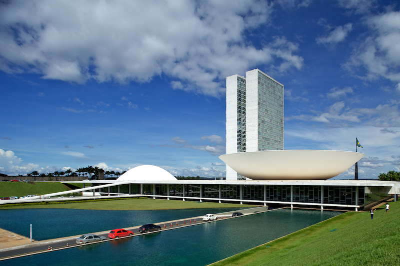 a tall white building sitting next to a body of water