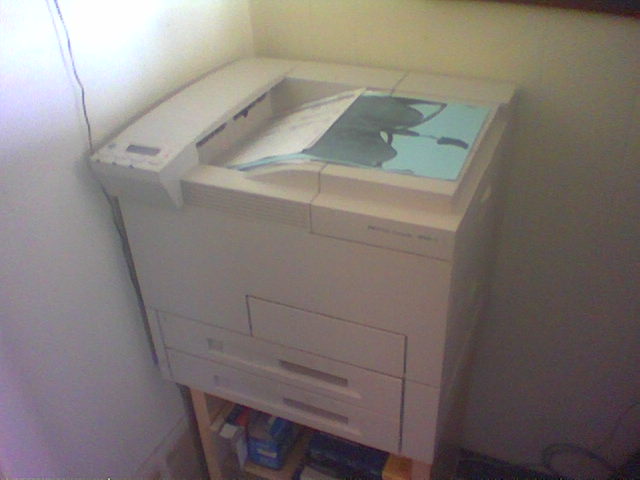 a small printer sitting on a stand in the corner