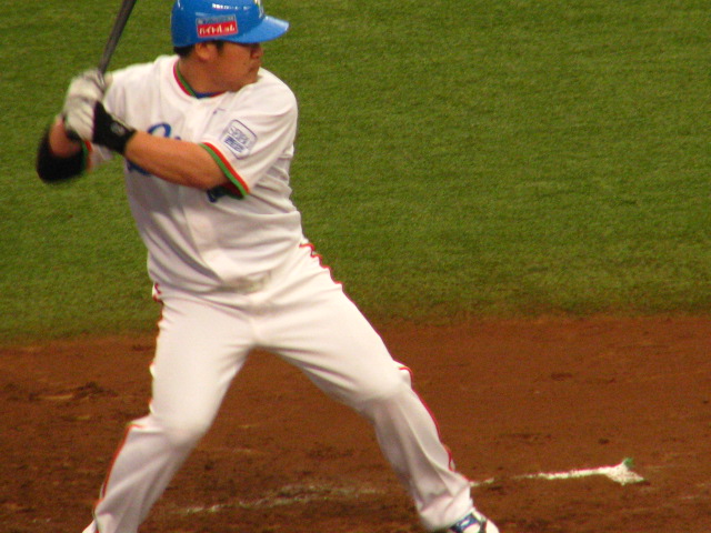 a baseball player with a blue cap is holding a bat