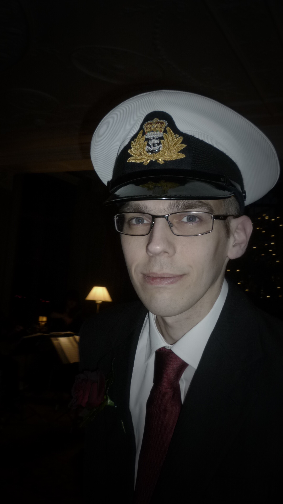 a man with glasses, a suit and a cap