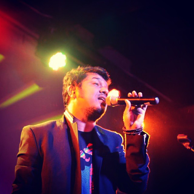 the singer is standing and speaking into his microphone