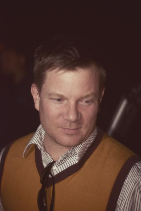 a man wearing a striped sweater and vest