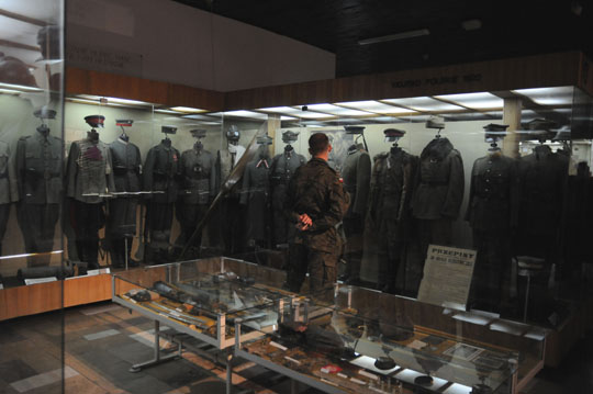people look at uniforms in a display case