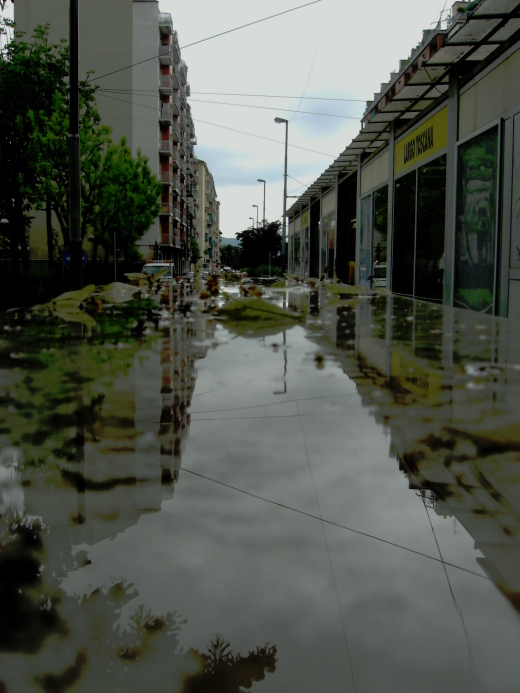 buildings line the streets with very little water on the pavement