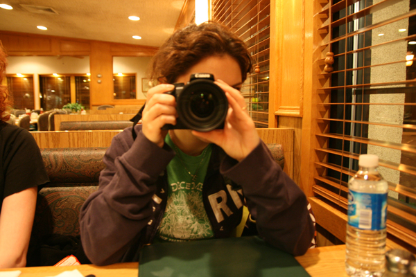 a person sitting at a table taking a picture