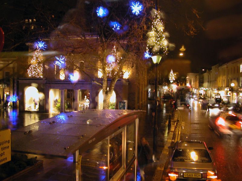 a city street at night with lit up christmas lights