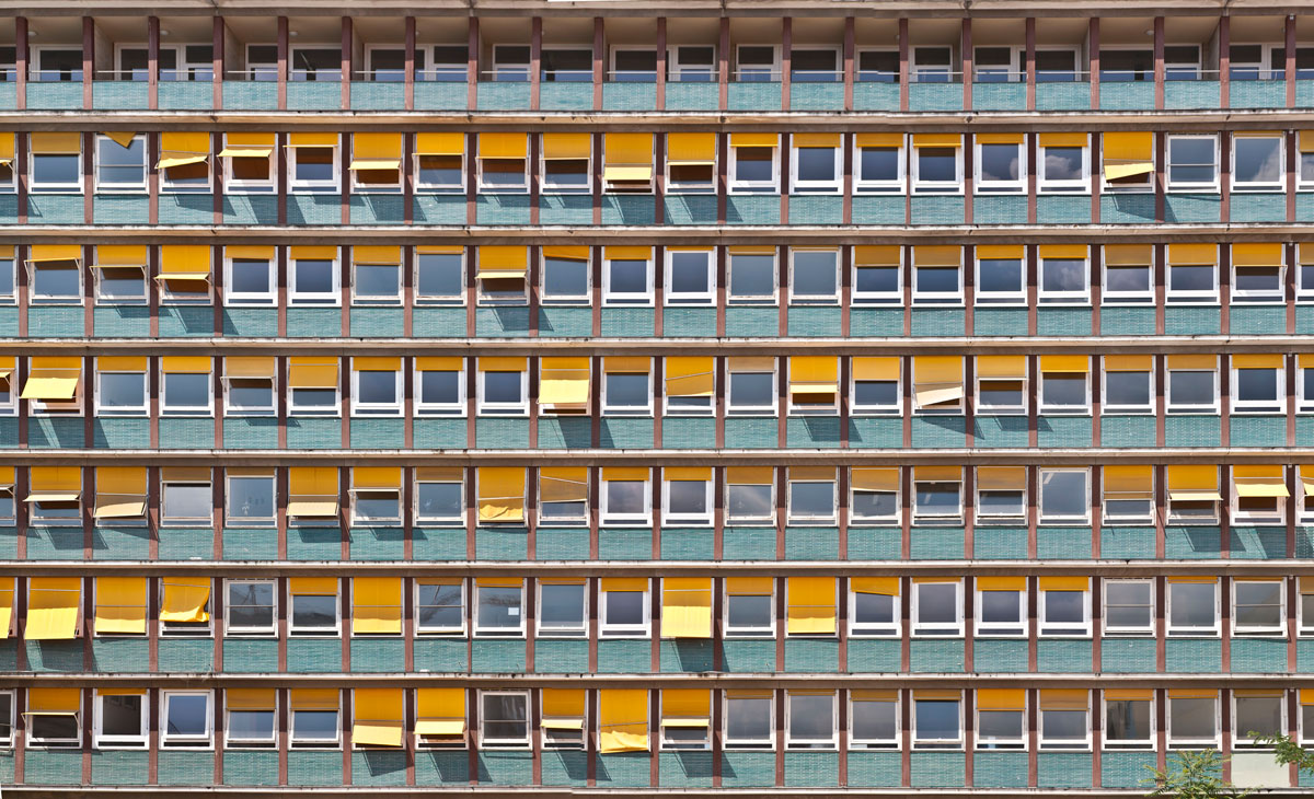 a yellow building facade with windows and many different colors
