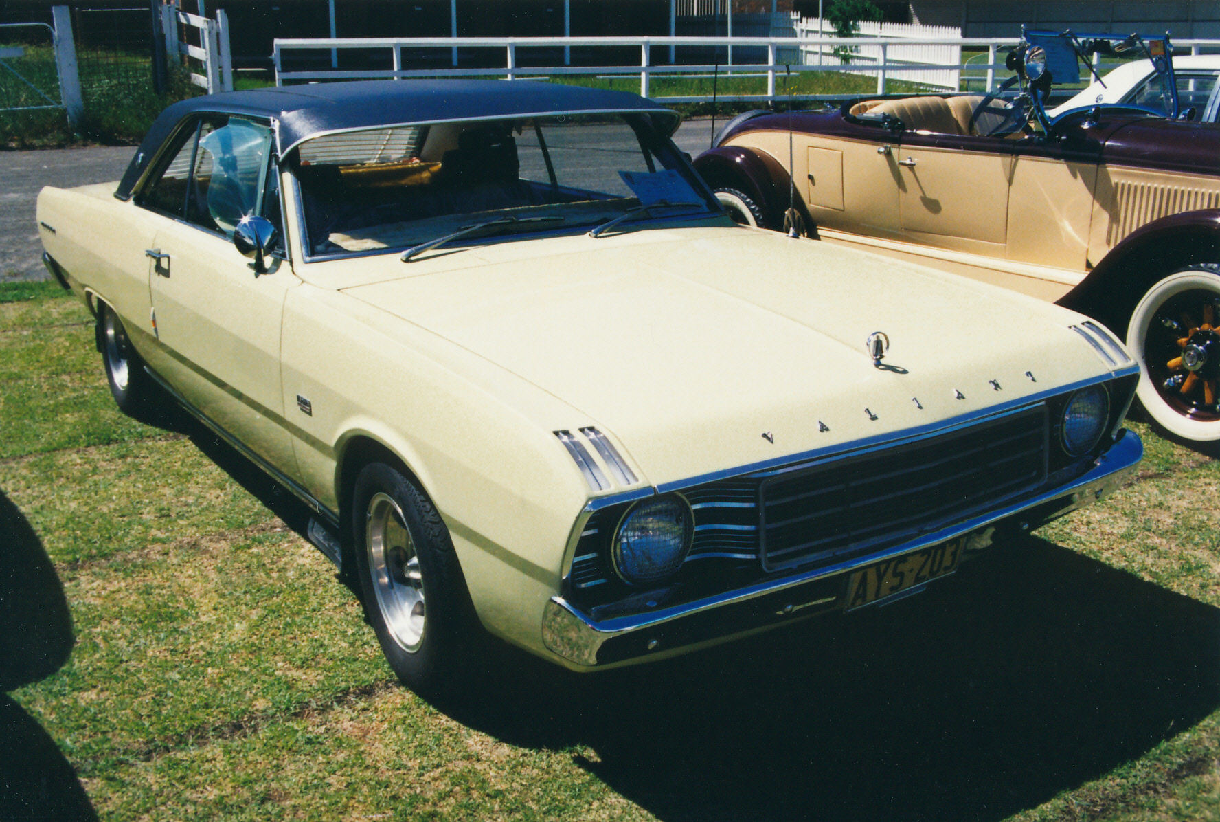 some old cars parked in a grassy field