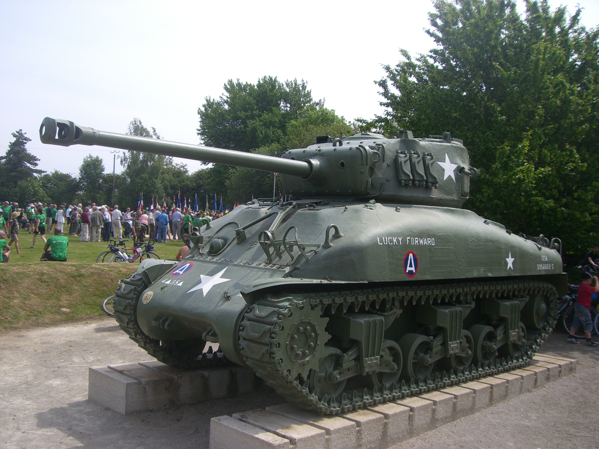 a tank in a museum display with people around