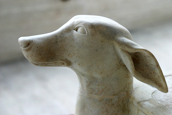 a small statue of a dog sitting on a surface