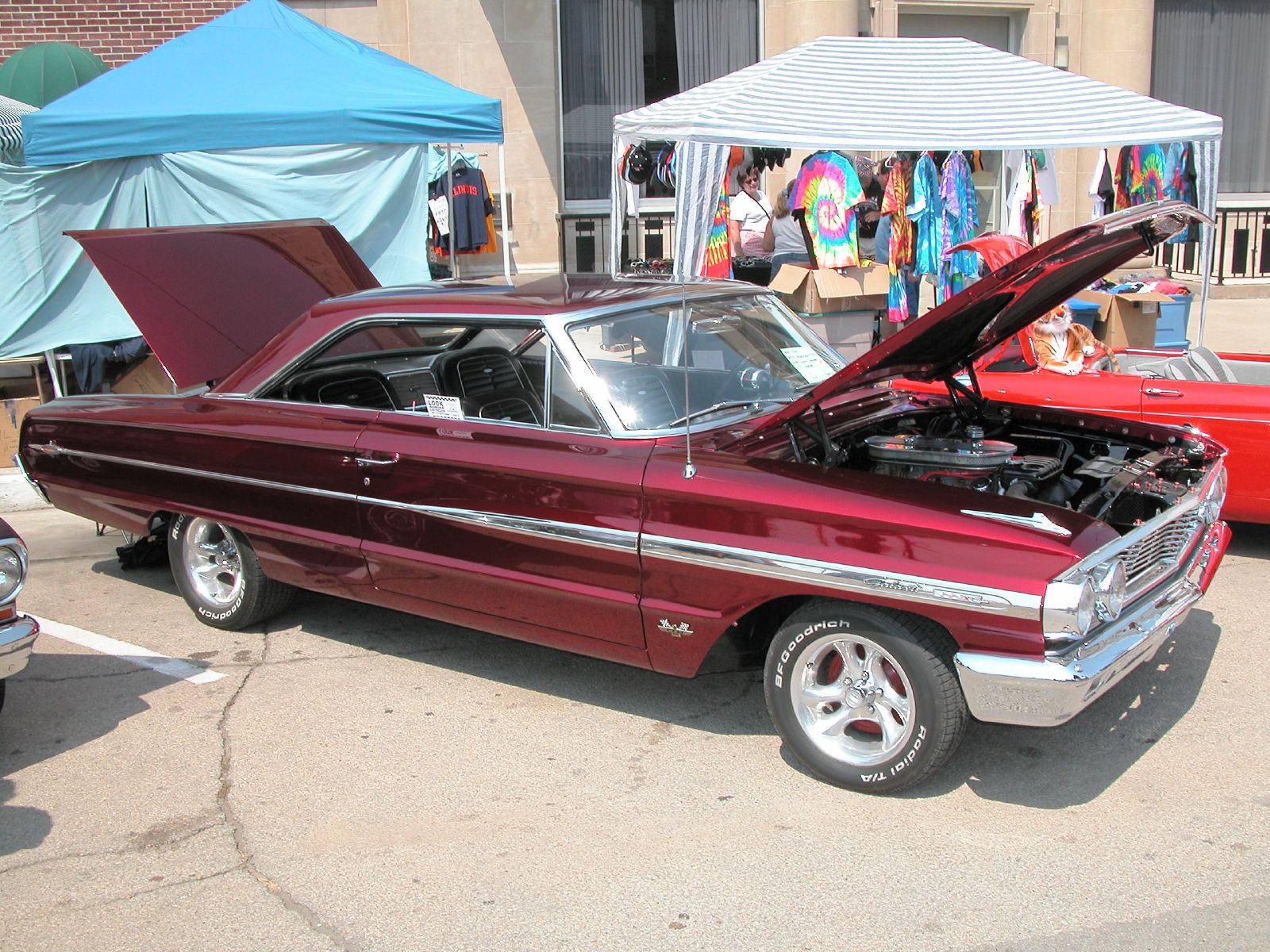 an old maroon car with the hood open