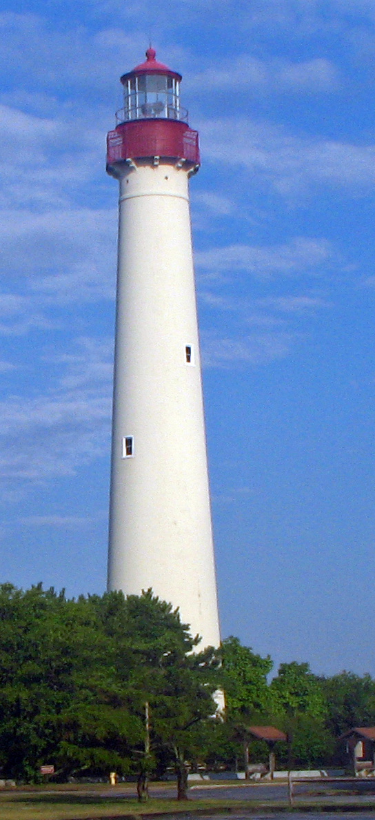 the lighthouse is near the water on a sunny day