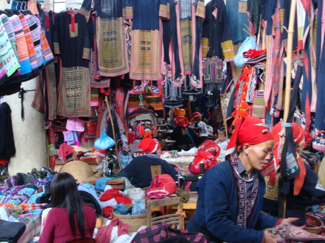 two women walking down a street at an asian market