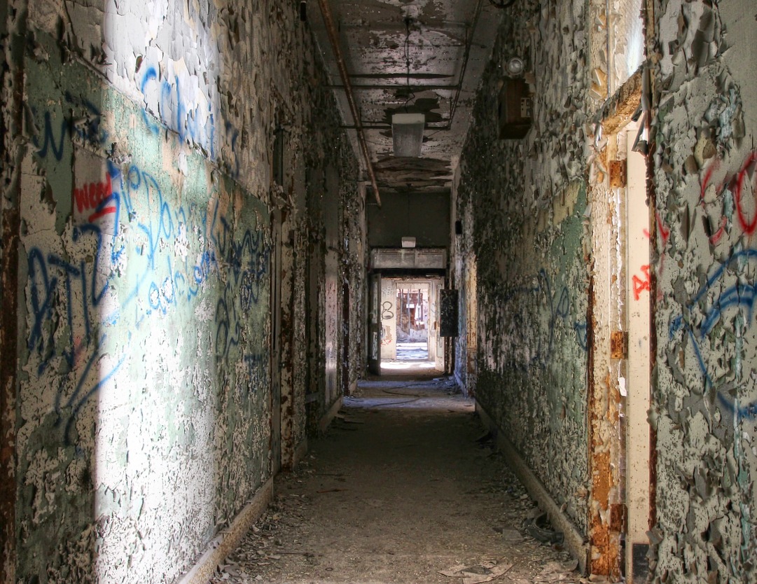 an old corridor with graffiti and wall paper