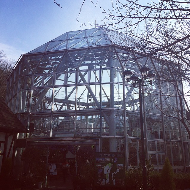 an iron frame structure in front of trees and buildings