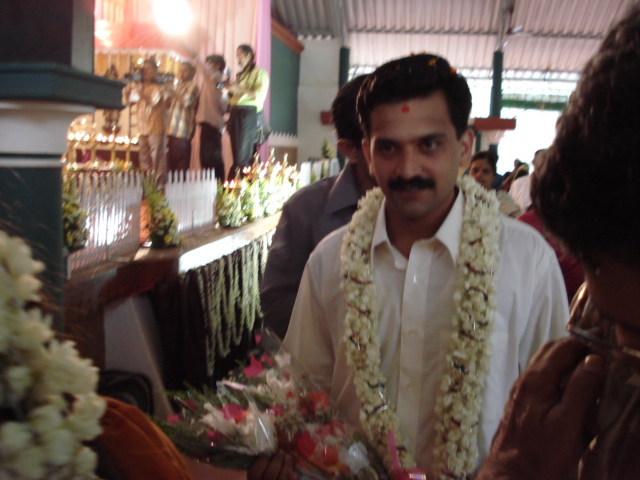 a man with a lei talking to two women in front of him