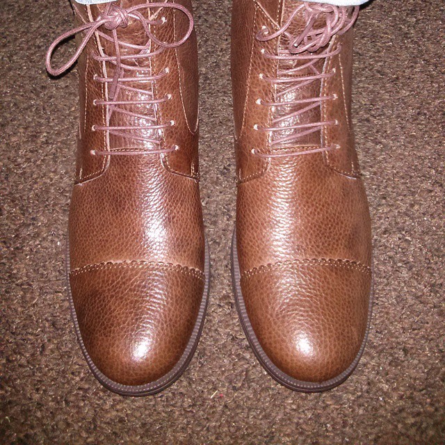 a pair of brown boots on top of a carpet