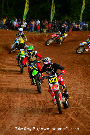 a group of people racing motorbikes on dirt