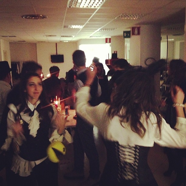 group of people wearing clothing in room with lights and candles