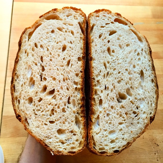 a half eaten piece of bread sitting on top of a  board