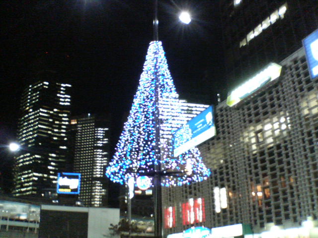 a christmas tree in a city with lights