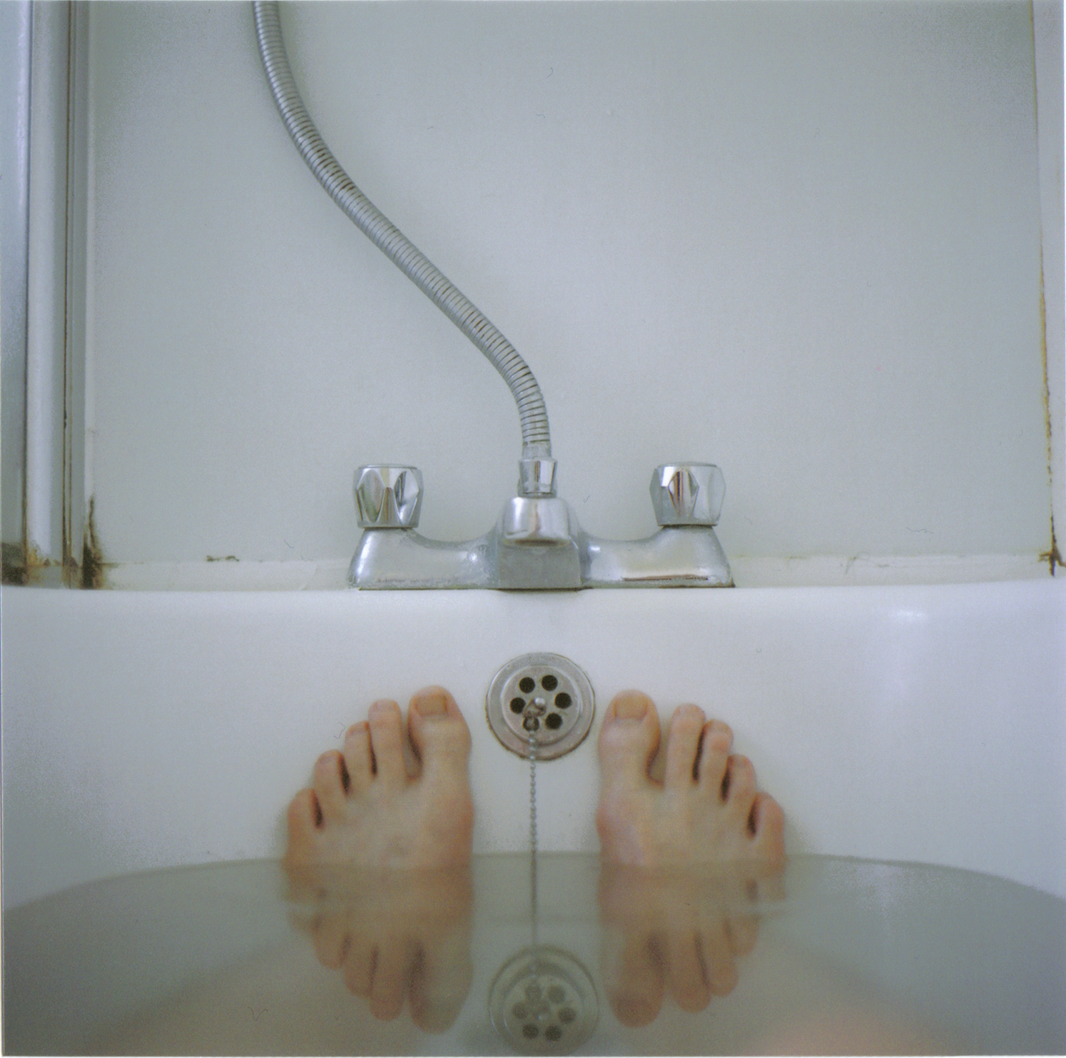 the feet of someone who are sitting in a tub