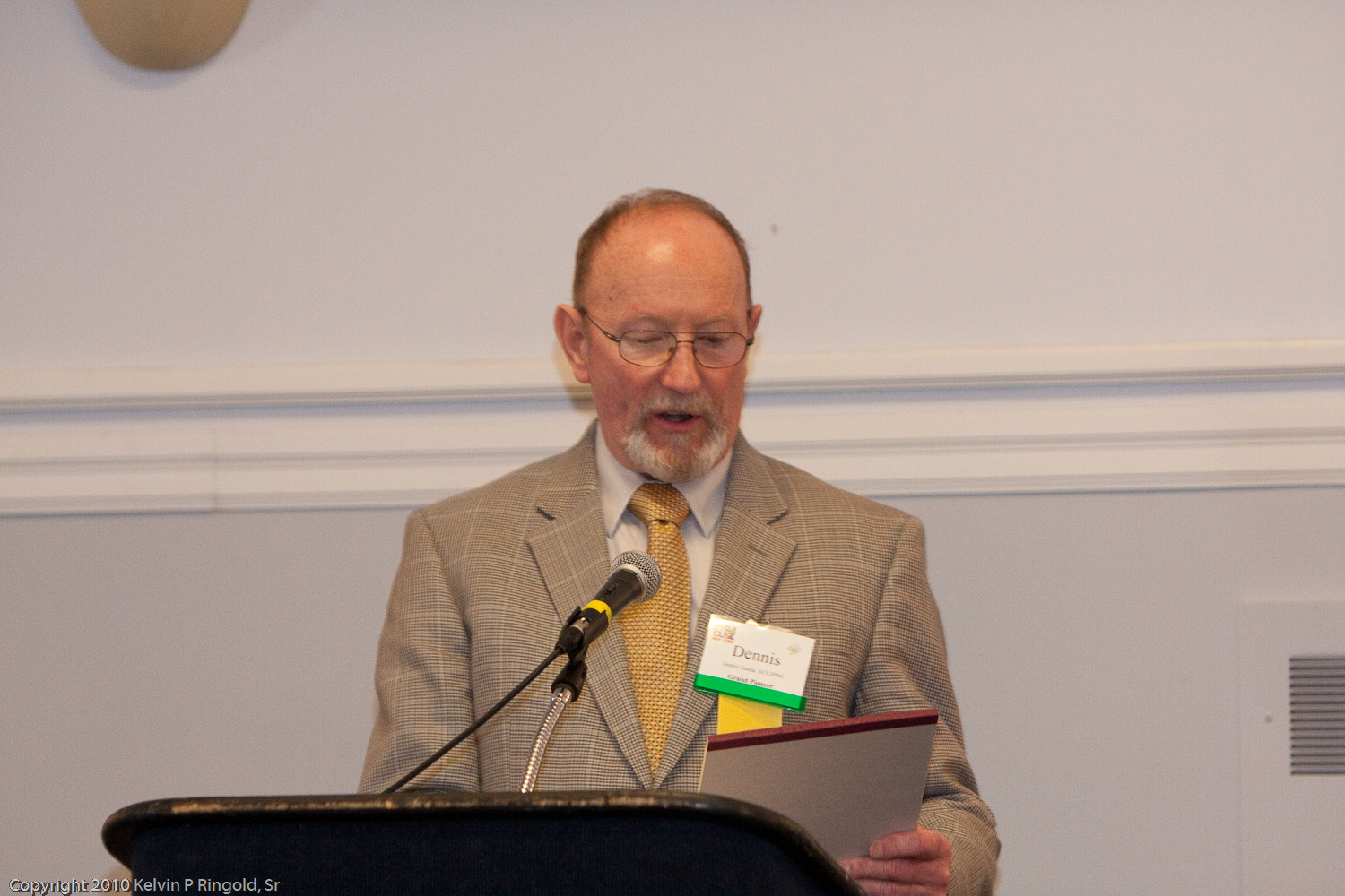 a man wearing a gray suit is giving a speech