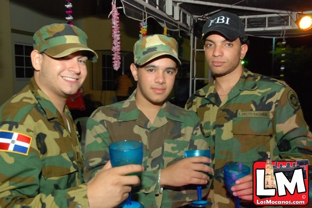 three soldiers in military clothes drink blue liquid