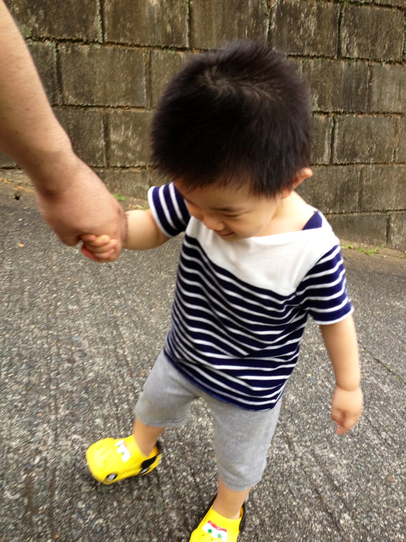 an adult holding the hand of a small child