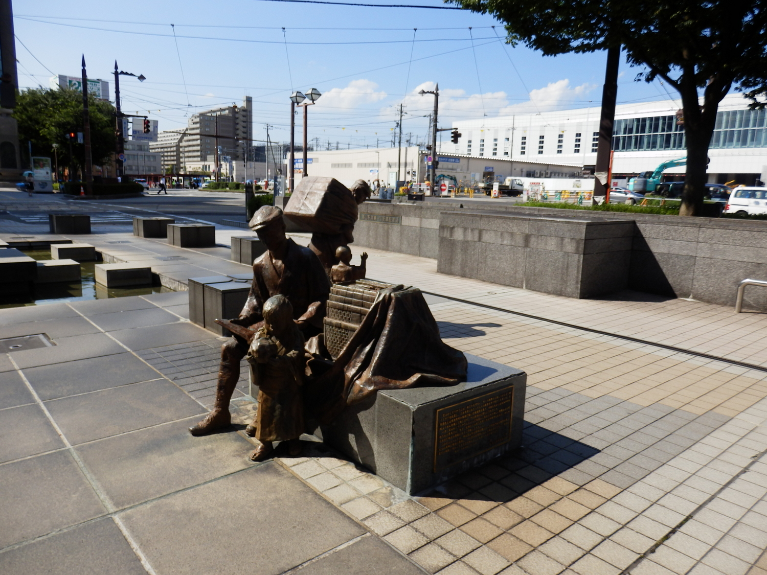 a statue of two people holding a guitar next to a bench