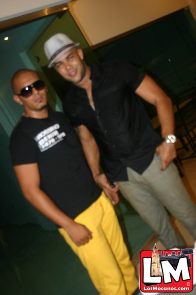 two young men standing next to each other wearing black shirts and yellow pants