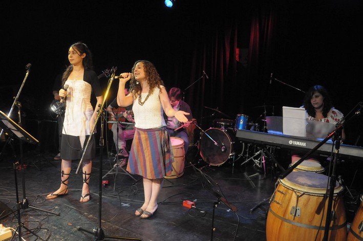two girls are singing in front of a keyboard and other instruments