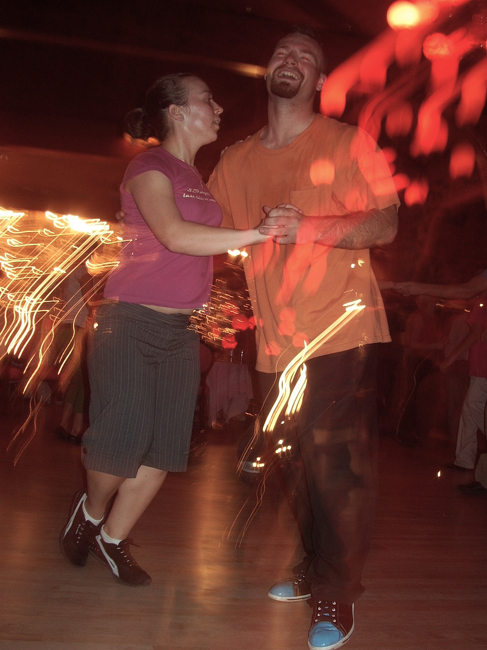 two people dancing in a room with a large number of lights