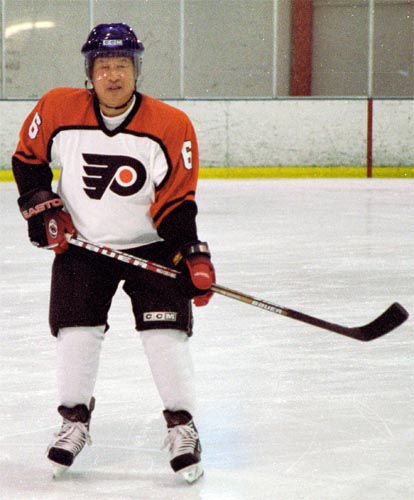 a man wearing an old time hockey jersey, skates on the ice