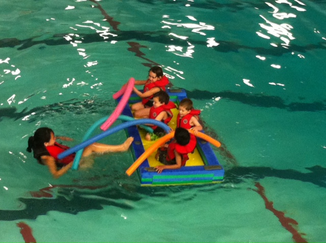 two groups of children sitting on inflatable boats