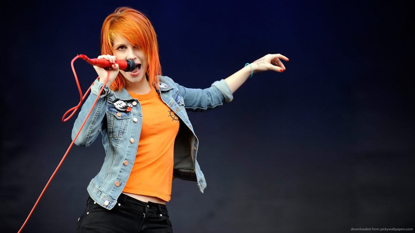 an ed sheer female singer with microphone and jeans on