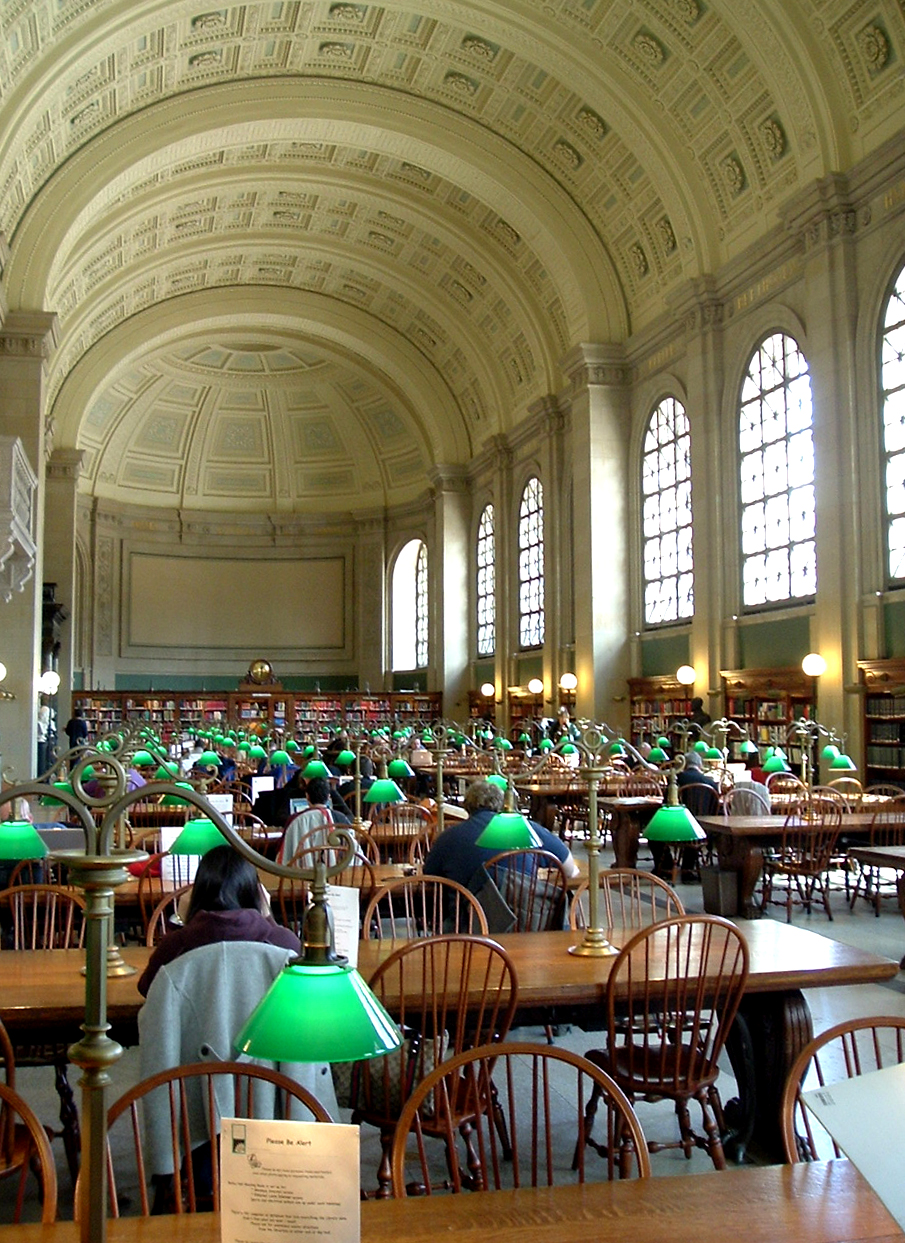 people sitting at tables in a large room with many windows