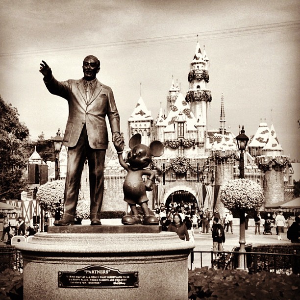 a statue of walt and mickey mouse at a amut park