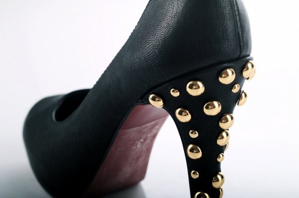 the top of a high heeled shoe with gold spikes