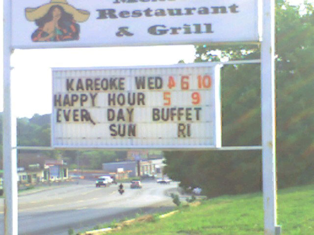 a sign on the side of a road for karoke wed happy hour