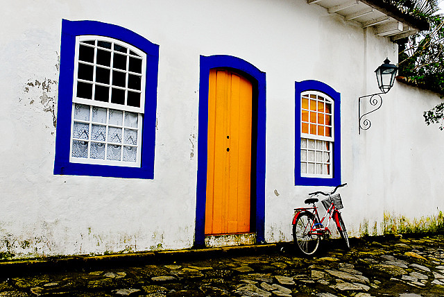 a bicycle parked outside of a colorful house