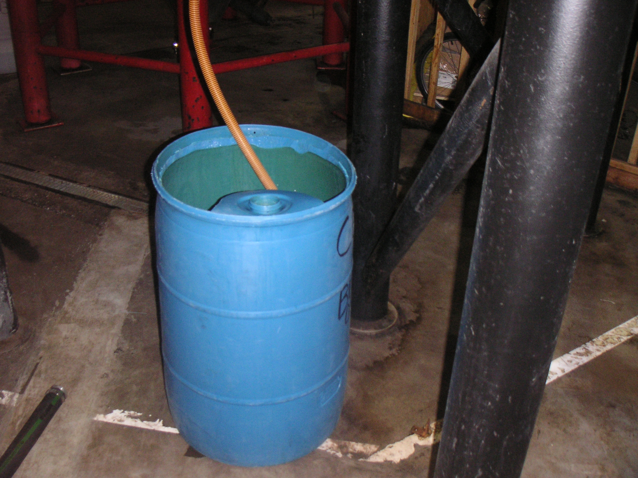 a bucket with some hose hanging from it