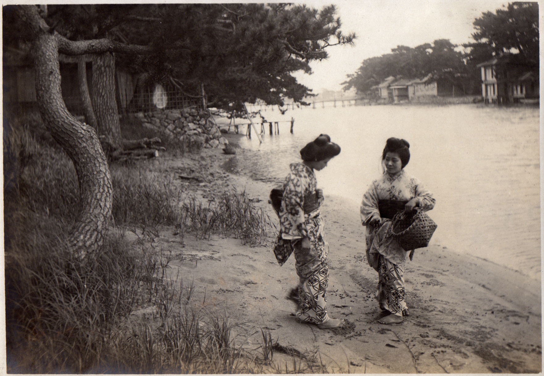 two woman walking next to each other near a body of water