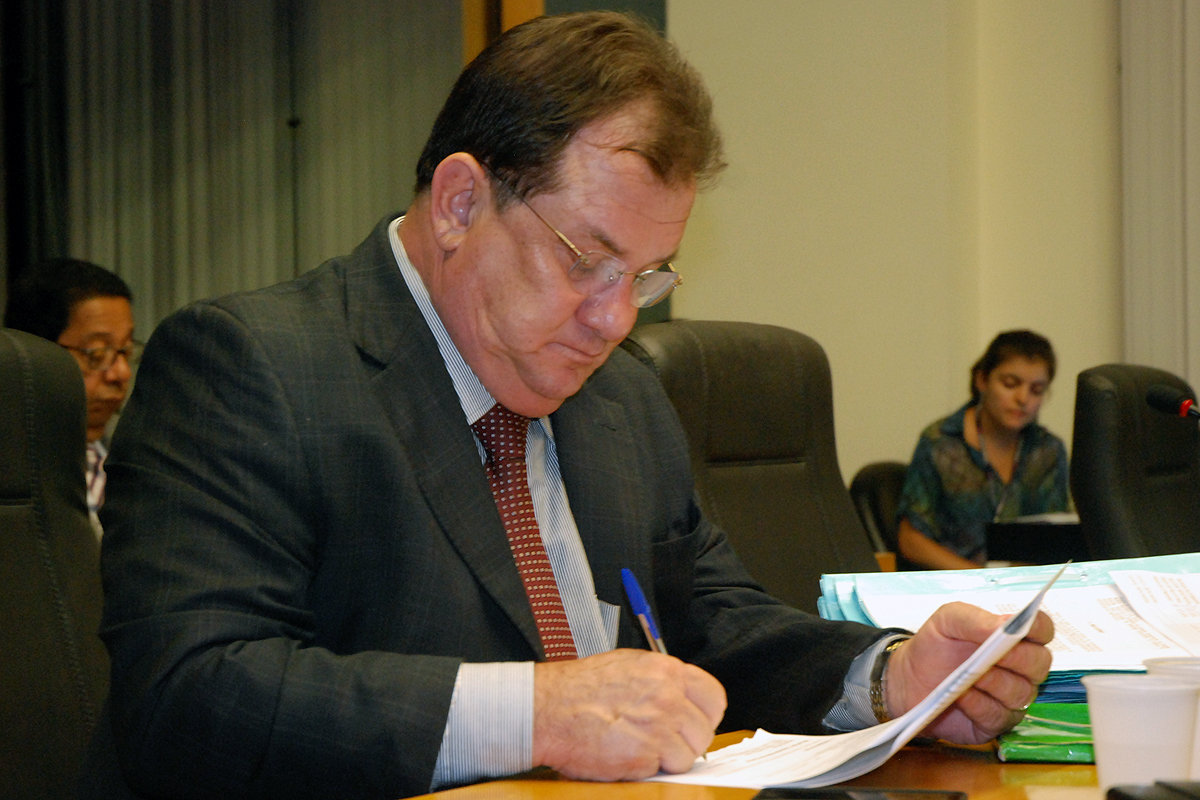 a man sits in a meeting room at a wooden desk