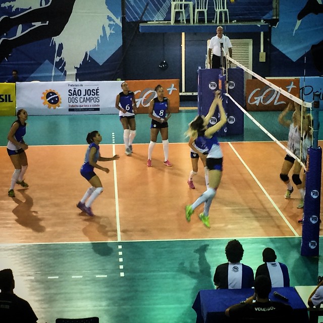 some women are playing volleyball in an arena