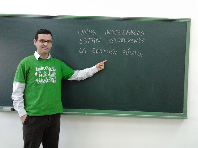 a man pointing to a blackboard with spanish words written on it
